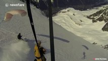 Speedrider skier rides an avalanche off a cliff