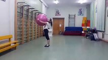 Girl Holding Exercise Ball Does Backflips