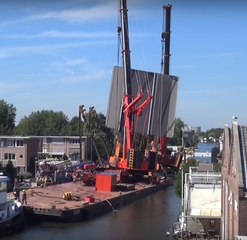 Two cranes and a piece of bridge collapsing