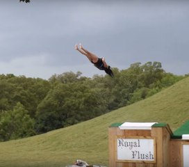 Uma mulher cai de costas retas ao sair de um tobogã aquático