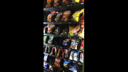 Des étudiants tentent de faire tomber les aliments bloqués dans le distributeur