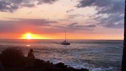 Une grosse vague envoie un catamaran dans les rochers