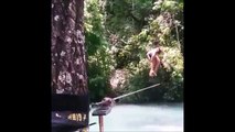 Une jolie fille en bikini fait des acrobaties sur une corde au dessus de l'eau