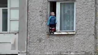 Un enfant russe joue au bord de la fenêtre au 8e étage