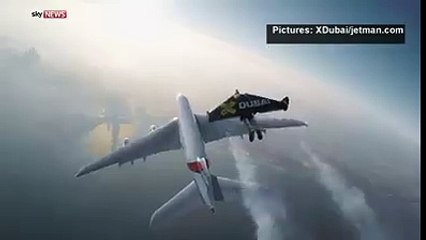 Watch two men wearing jet-propelled wings fly in formation wit...