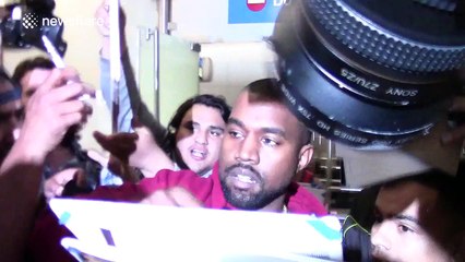 Kanye West mobbed on arrival at LAX airport