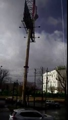 Un énorme panneau publicitaire s'écrase sur des voitures