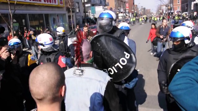 A Punk Sporting A Bright Red Mohawk Confronts Riot Police During COBP Protest
