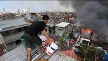 Centenares de filipinos luchan contra un incendio en un barrio de Manila