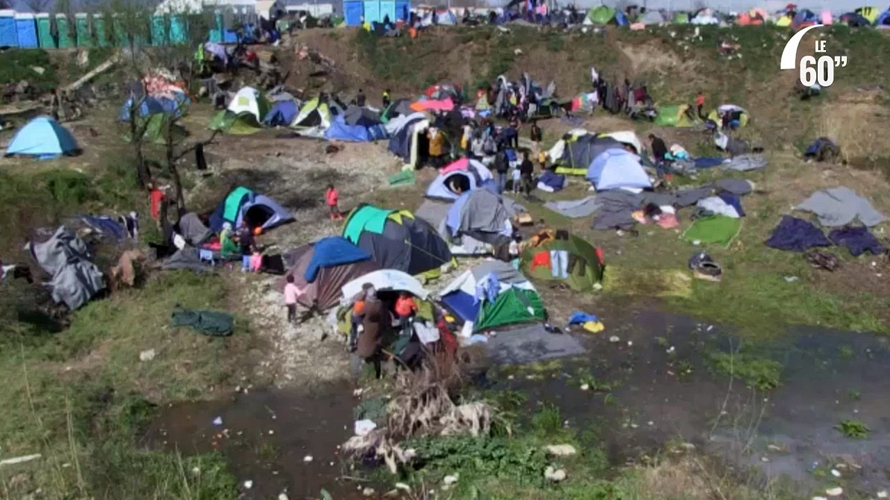 Un nouveau-né lavé au dessus d'une flaque d'eau au camp d'Idomeni en Grèce