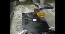 Cutting a laptop with a waterjet cutter.