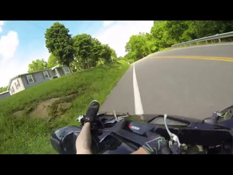 Un motard en short et torse nu glisse dans un virage