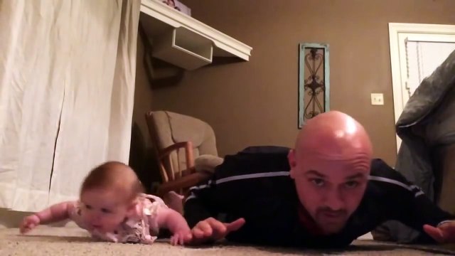 Un bébé et son papa en plein entrainement - Séance de muscu adorable