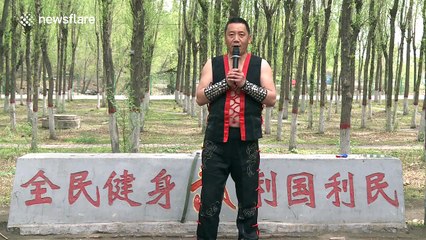 Martial artist uses his stomach to blow dart out and pop balloon behind glass