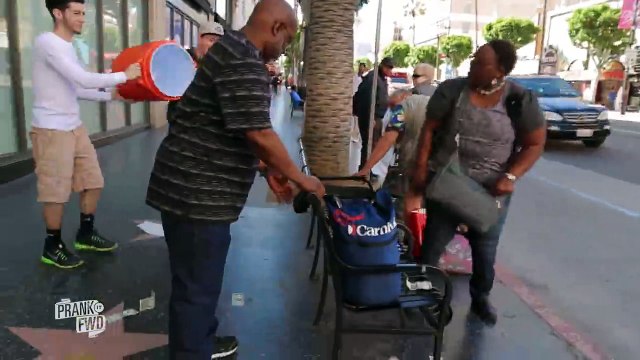 Des blagueurs très généreux font croire à des passants qu'ils leur versent de l'eau mais c'est en fait des billets