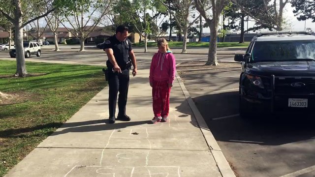 Un policier joue à la marelle avec une fillette dans la rue. Magique