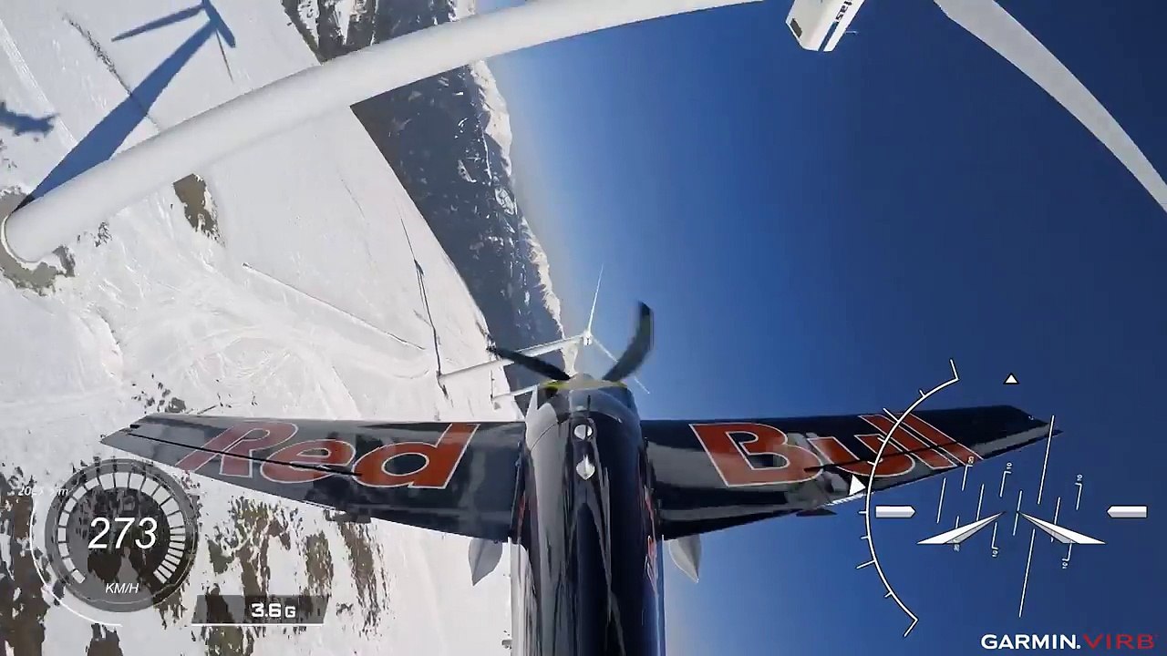 Un avion de voltige slalome dans un champ d'éoliennes