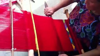 Mujer artesana de Zinacantán tejiendo a mano en telar de cintura.
