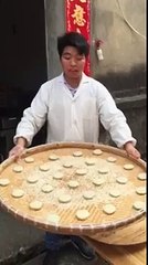 Un homme jongle avec des pâtons sur des plateaux