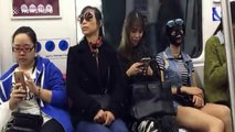 Woman uses strange black facial mask on underground train