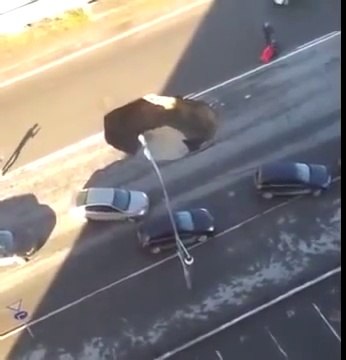 La route s'effondre et un trou béant menace d'avaler les voitures qui roulent dessus