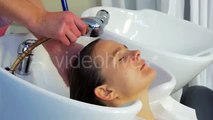 Man Stylist Hairdresser is Washing the Hairs With Bathroom Hose Pipe Upon the Sink For a Woman With