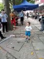 Ce petit chinois se sert d'un gros bâton pour protéger sa grand-mère et repousser les policiers