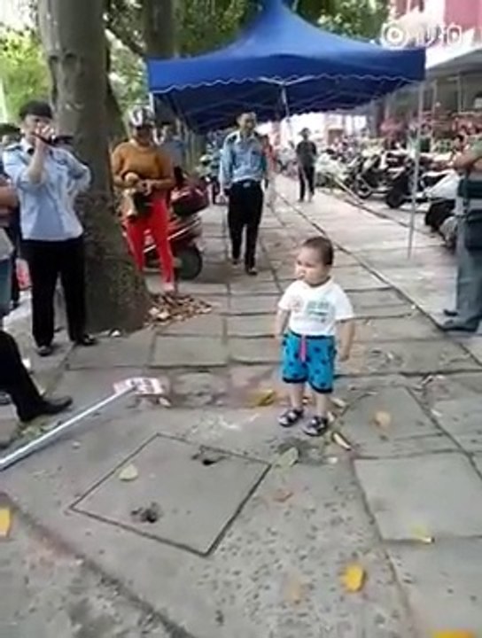 Ce petit chinois se sert d'un gros bâton pour protéger sa grand-mère et repousser les policiers