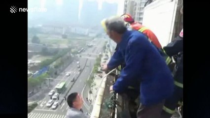 Firefighters rescue man hanging form top of a building