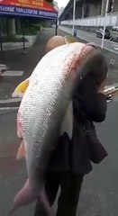 Crazy Man is Lifting Big Fish on Shoulders