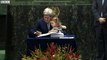 John Kerry held his granddaughter as he signed the book during the signature ceremony for the Paris Agreement