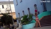 Cubana protesta frente a una estación de policía semi desnuda.