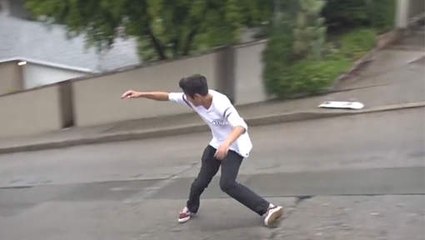 Un gars arrive à faire du skate sans skate sur une route mouillée