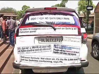 Vijay Goel drives a car pasted with news reports against Odd-Even scheme