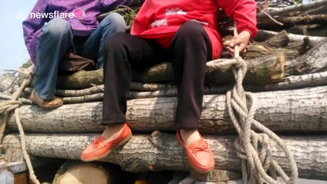 Three people travel on top of overloaded tractor on motorway