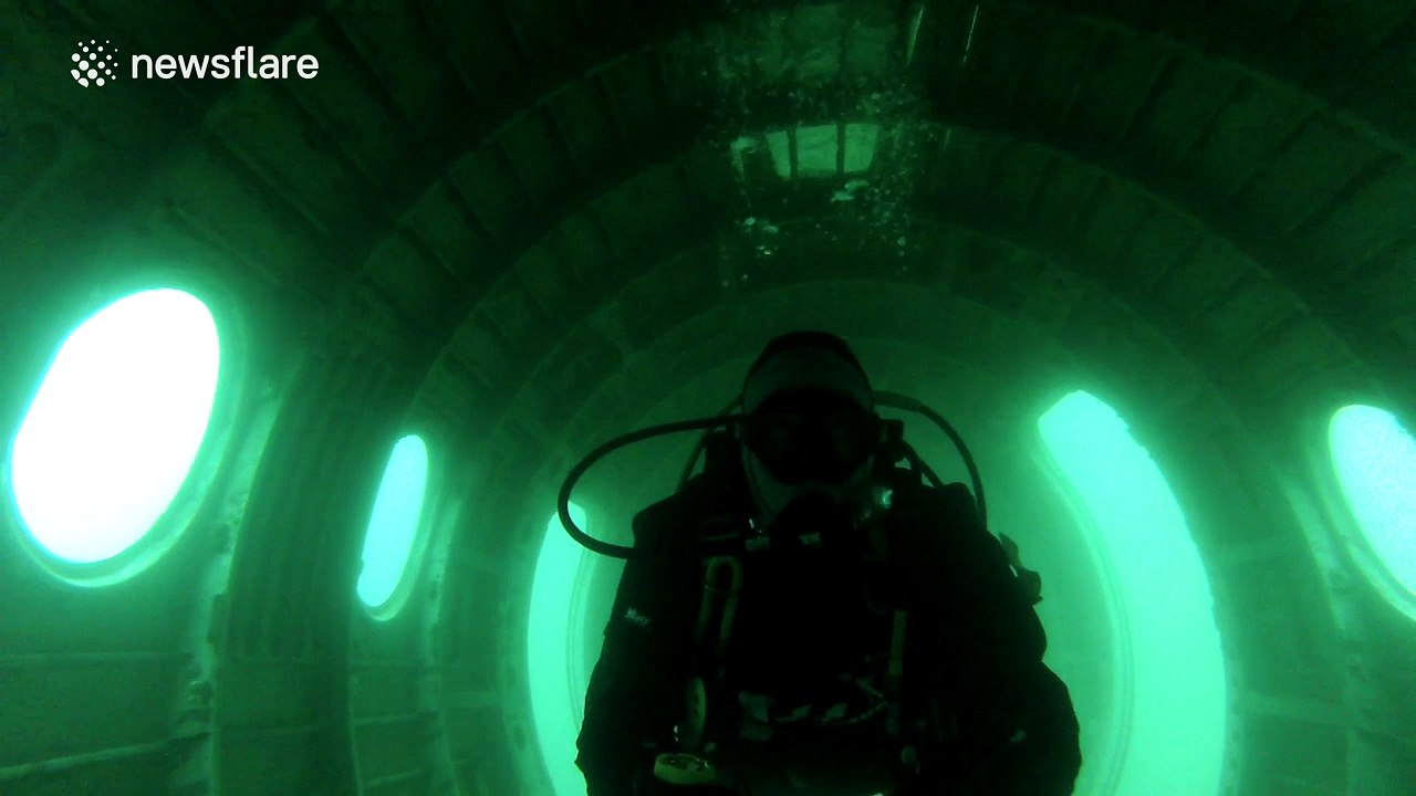 Diver explores plane wreckage at the bottom of the ocean