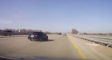 Complètement fou : des hommes changent une roue de voiture sur la voie centrale de l'autoroute