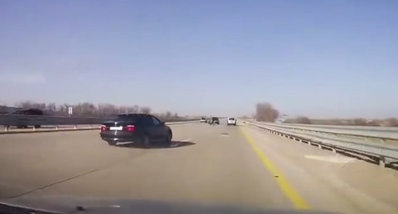 Complètement fou : des hommes changent une roue de voiture sur la voie centrale de l'autoroute