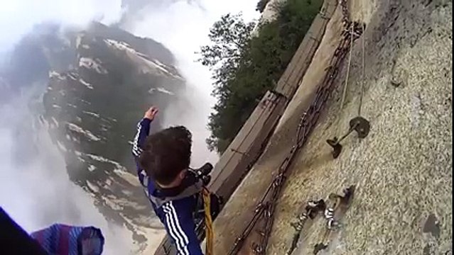 Il marche à flan de montagne sur de simples planches... Flippant