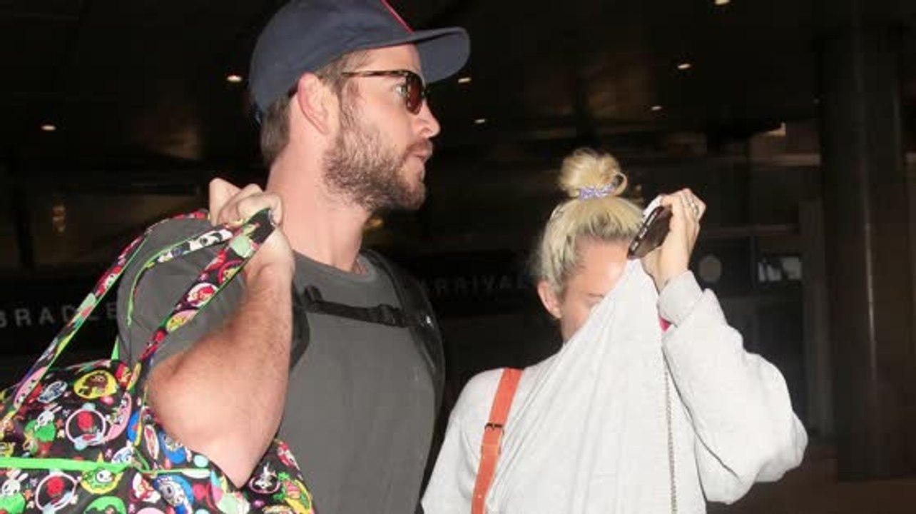 Liam Hemsworth and Miley Cyrus Hold Hands as Th...
