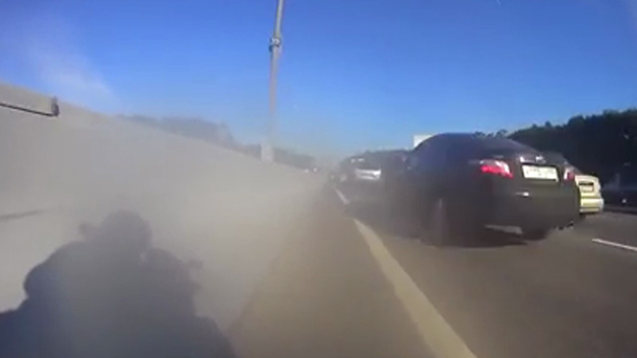 Un motard remonte la file de voiture à grande vitesse, ca défile très vite !
