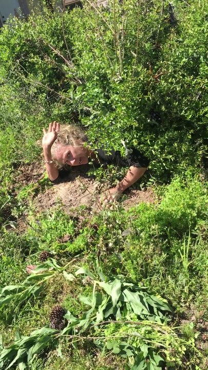 Cette folle cherche une pièce de voiture à travers un buisson de son jardin