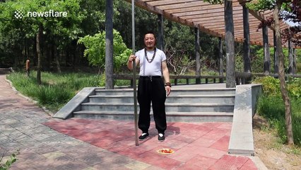 Man uses giant chopsticks to feed fruit to friend