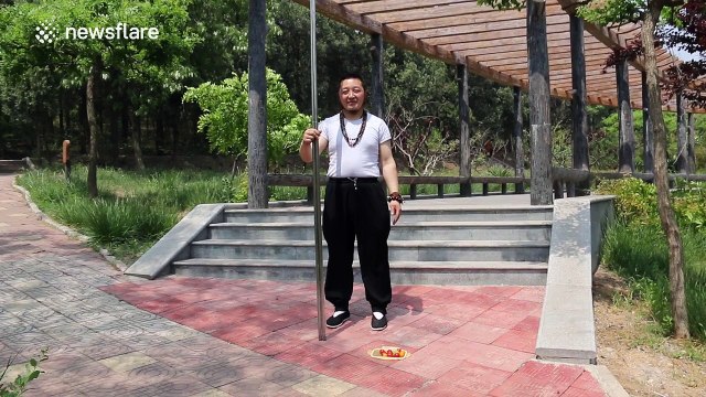 Man uses giant chopsticks to feed fruit to friend