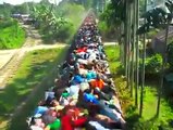 A train in india extremely loaded with passengers on the roof