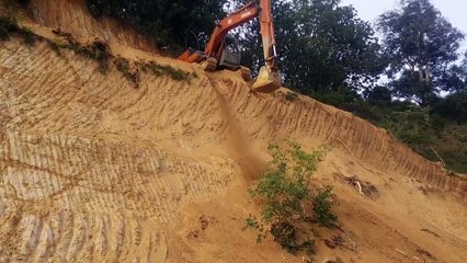 Il descend une paroi verticale avec une pelleteuse