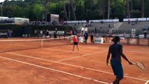 Gaël Monfils smashe en sautant au-dessus d'une joueuse