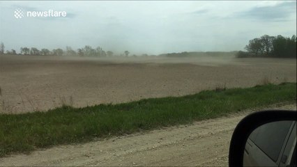 Dust cloud rolls across Minnesota field