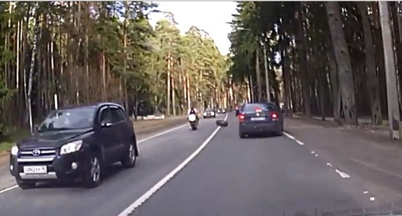 Un motard malchanceux chute à cause d'une roue de voiture