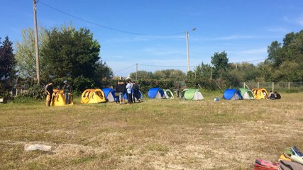 Des migrants aidés par Itinérance de retour derrière la salle Nordez